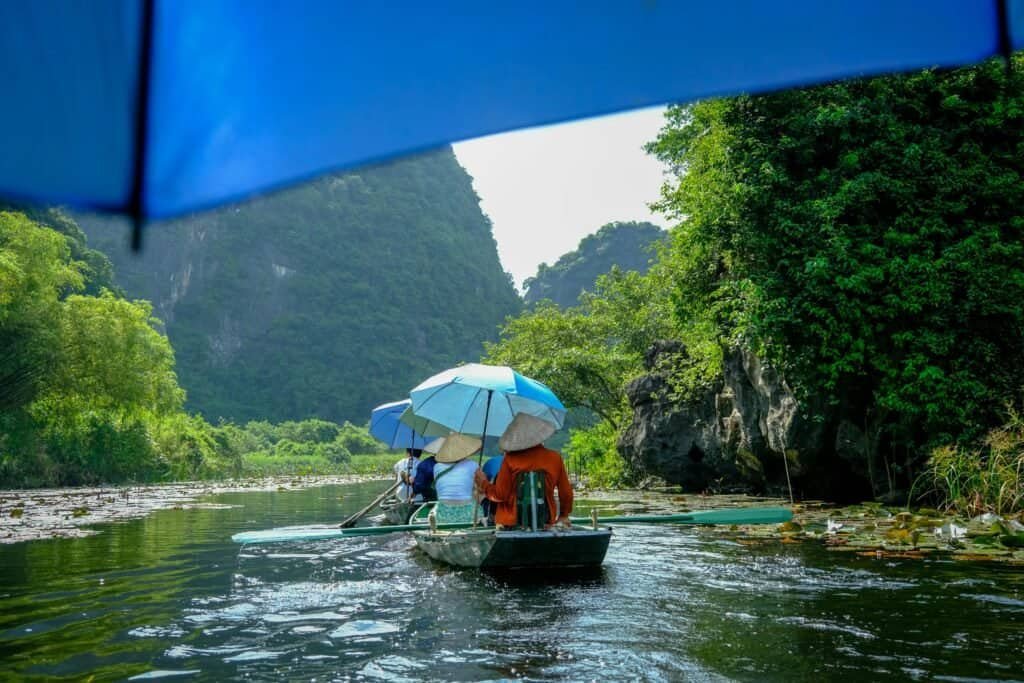 Boat ride through Tam Coc river with limestone karsts in Ninh Binh Vietnam Travel Guide 2025 | Top Places to Visit, Things to Do & Travel Tips Boat ride through Tam Coc river with limestone karsts in Ninh Binh.