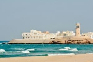 A serene view of Sur Lighthouse and traditional buildings on the Omani coast, Oman