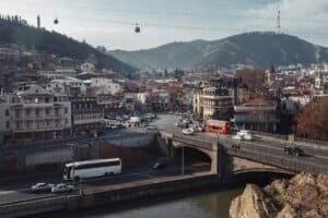 A vibrant view of Tbilisi's landscape featuring urban architecture, a bridge, and cable cars, Georgia