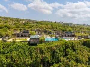 Aerial view of a luxurious villa with an infinity pool on a cliffside in Bali, Indonesia