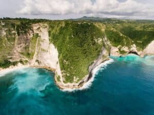 Breathtaking aerial view of rugged coastal cliffs and turquoise ocean in a serene natural landscape Bali Bali Budget Travel Guide 2026: Travel Bali Cheap Under $50/Day Breathtaking aerial view of rugged coastal cliffs and turquoise ocean in a serene natural landscape, Bali