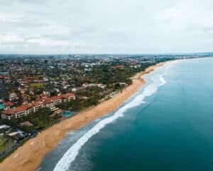 Discover Bali's stunning beachfront with waves and cityscape from above, Bali