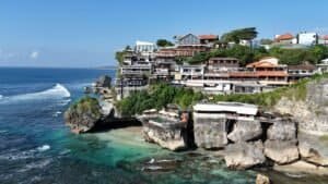 Scenic view of cliffside cafes along Bali's coastline, vibrant and lively, Bali