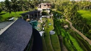 Stunning aerial shot of a luxury resort in Bali, Indonesia, surrounded by green rice terraces and palm trees