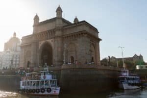Stunning view of the iconic Gateway of India with boats and visitors at sunset in Mumbai, India